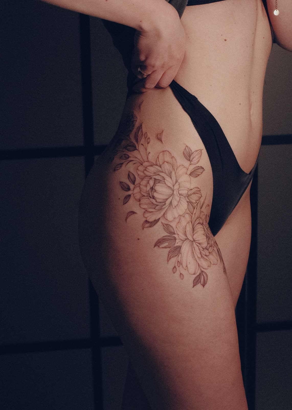Duże piwonie na biodrze i udzie – tatuaż fine line