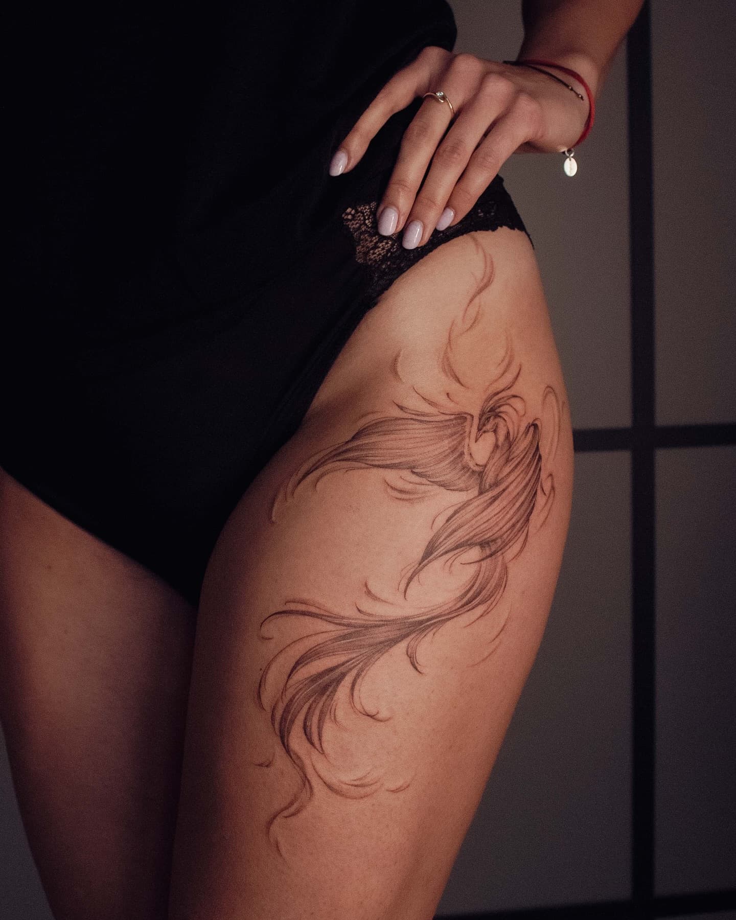 Feniks na udzie i biodrze – tatuaż fine line