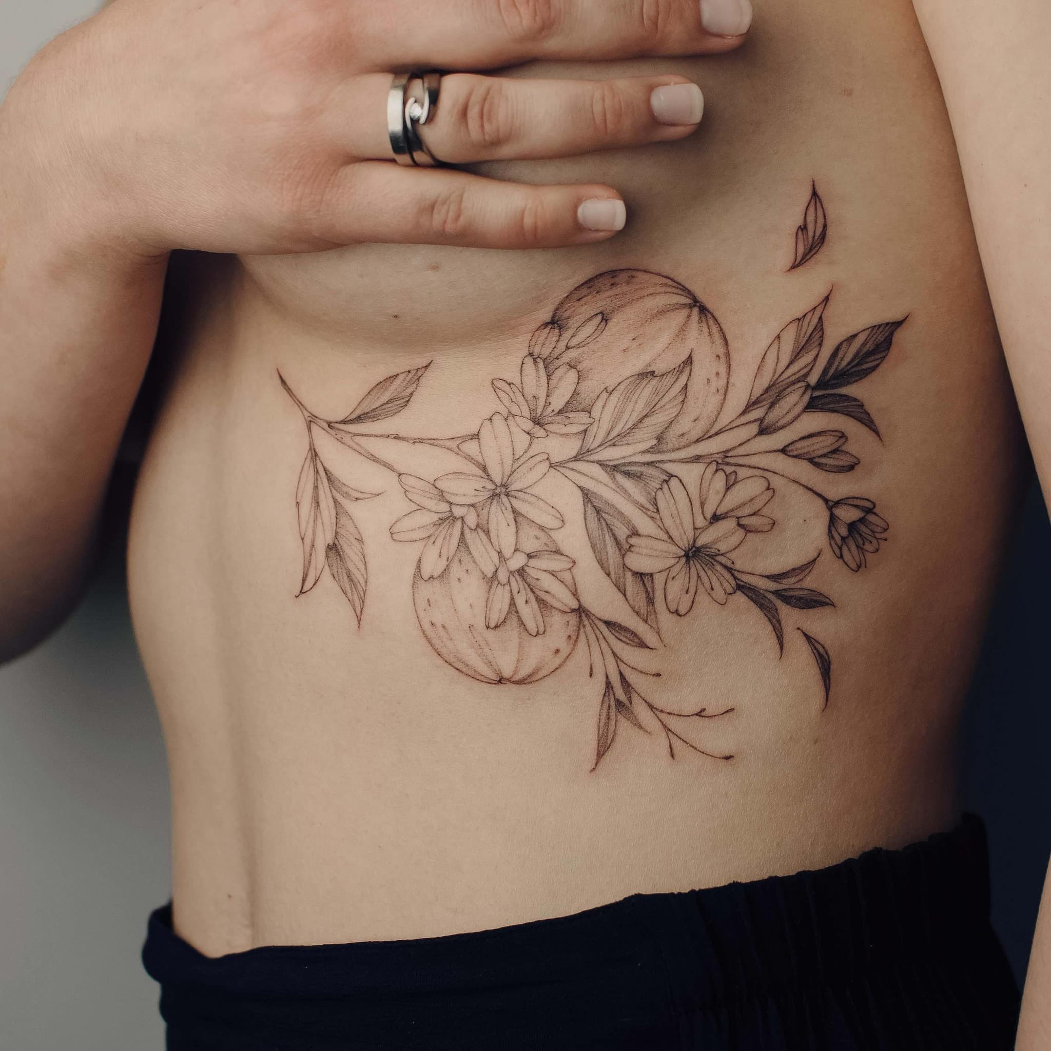 Kwiaty i księżyc na żebrach – tatuaż fine line