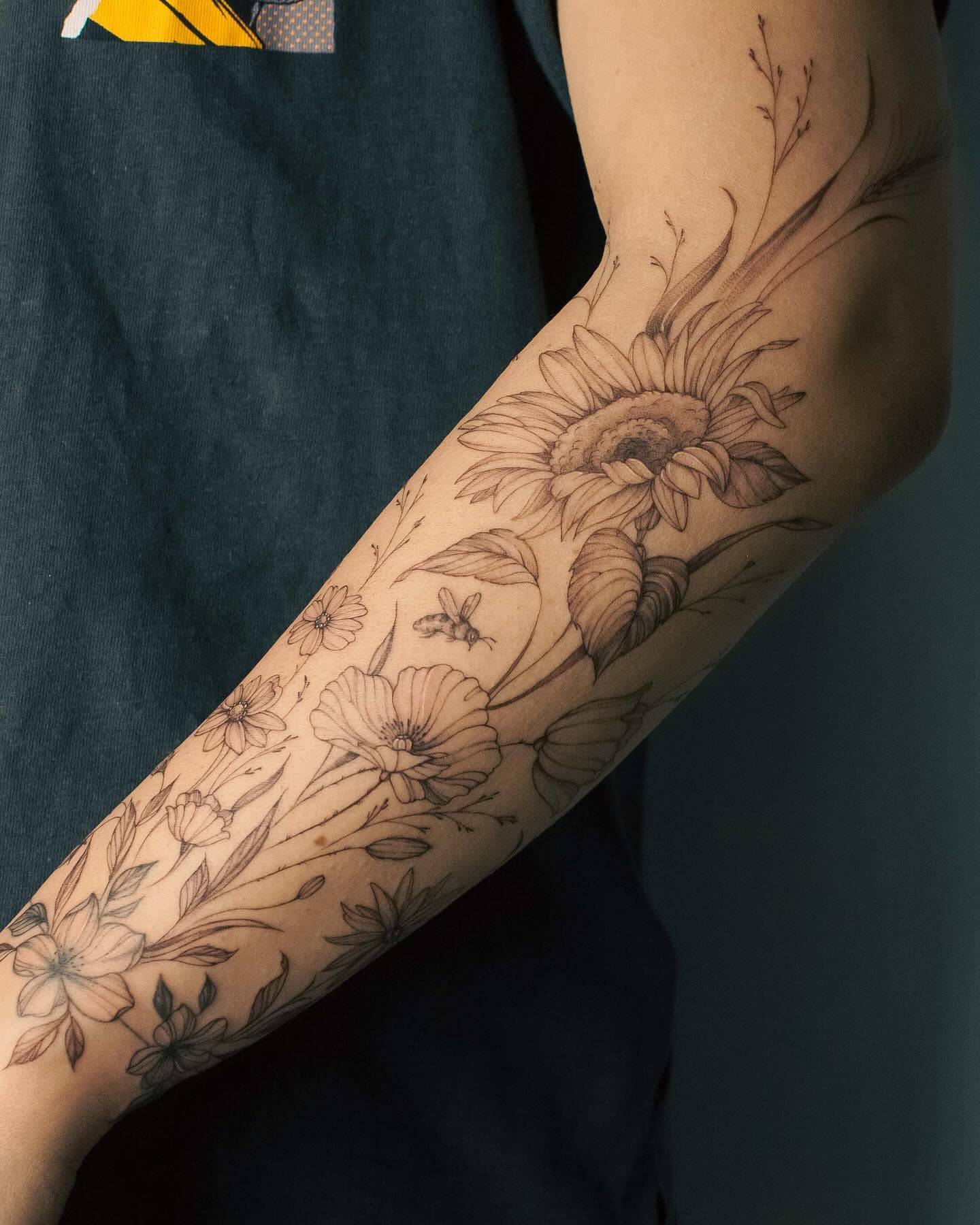 Kwiatowy rękaw na ręce – tatuaż fine line